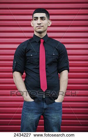 Stock Photo - A man's red tie matching the wall color behind him; San Francisco, California, USA. Fotosearch