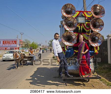 A Mixed Race Couple Stands On The Back Of A Decorated Cart On The Side Of The Road; Ludhiana, Punjab, India View Large Photo Image Stock Photo - A Mixed Race Couple Stands On The Back Of A Decorated Cart On The Side Of The Road; Ludhiana, Punjab, India. Fotosearch