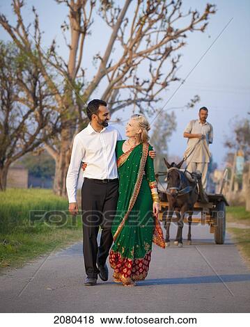 Stock Photo - A Mixed Race Couple Walking In An Embrace Down A Path; Ludhiana, Punjab, India. Fotosearch