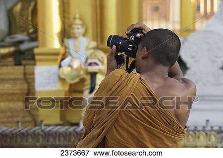 A monk takes a photograph at Shwedagon Pagoda; Yangon, Burma View Large Photo Image Stock Photo - A monk takes a photograph at Shwedagon Pagoda; Yangon, Burma. Fotosearch