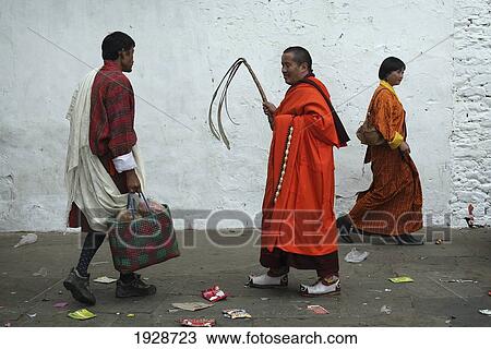 Stock Image - A Monk With A Whip At Tashi Chhodzong. Fotosearch