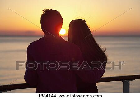 A Mother And Daughter Standing At A Railing Watching A Sunset Over The Caribbean; Bahamas View Large Photo Image Picture - A Mother And Daughter Standing At A Railing Watching A Sunset Over The Caribbean; Bahamas. Fotosearch