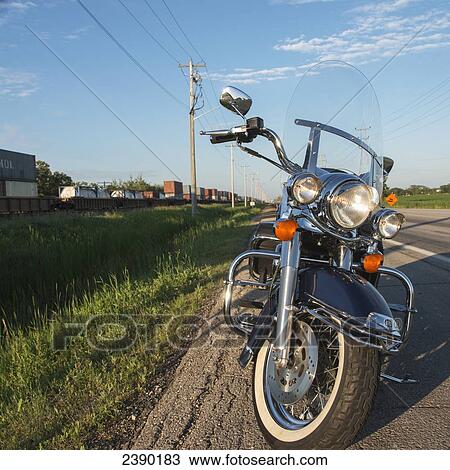 A motorcycle parked on the roadside with a train traveling by; Manitoba, Canada View Large Photo Image Stock Image - A motorcycle parked on the roadside with a train traveling by; Manitoba, Canada. Fotosearch