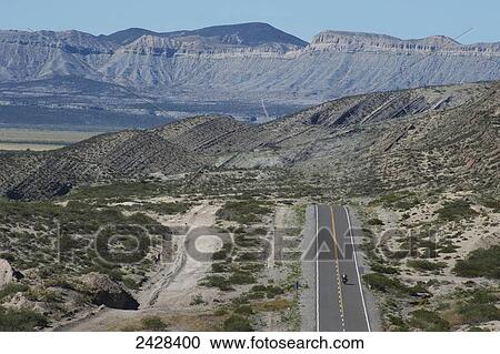 A motorcycle travels on route 40 with rugged mountains in the distance; Neuquen Province, Argentina View Large Photo Image Stock Image - A motorcycle travels on route 40 with rugged mountains in the distance; Neuquen Province, Argentina. Fotosearch