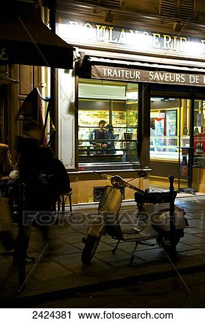 Stock Image - A motorized scooter parked outside a retail shop; Paris, France. Fotosearch