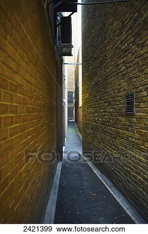 Stock Photo - A narrow alley between two brick walls; London, England. Fotosearch