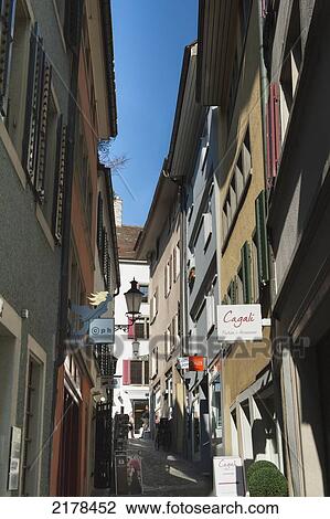 A Narrow Walkway Between Buildings With Retail Signs Mounted To The Walls; Zurich Switzerland View Large Photo Image Stock Image - A Narrow Walkway Between Buildings With Retail Signs Mounted To The Walls; Zurich Switzerland. Fotosearch