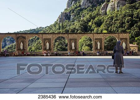 Stock Photograph - A nun standing outside the Benedictine Abbey; Montserrat, Catalonia, Spain. Fotosearch