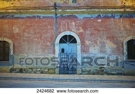 Stock Image - A old building with arched doorway and window; Sardinia, Italy. Fotosearch