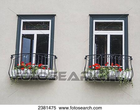 Stock Photography - A pair of windows with matching flower planters; Quebec City, Quebec, Canada. Fotosearch