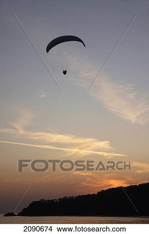 Picture - A Paraglider Making The Final Sunset Descent Over Oludeniz At The Turquoise Coast, Southern Turkey. Fotosearch
