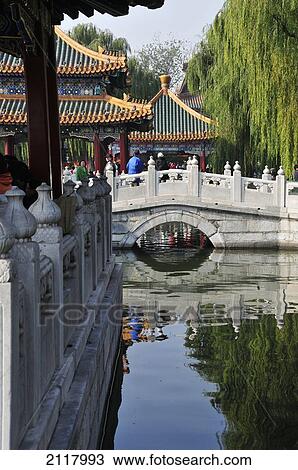 Stock Image - A Pedestrian Bridge Over A Pond; Beijing China. Fotosearch