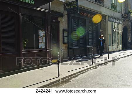 Stock Image - A pedestrian in the historial district of the Marais; Paris, France. Fotosearch