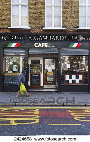 Stock Photo - A pedestrian walks by a cafe; London, England. Fotosearch