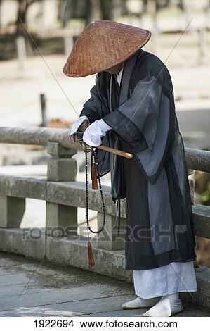 Picture - A Person In A Robe And Conical Hat At The Todaiji Temple; Nara, Japan. Fotosearch