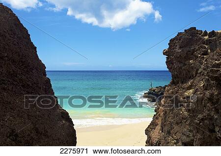 A person standing on the rugged rocks on the coast of an hawaiian island; Hawaii, United States of America View Large Photo Image Stock Image - A person standing on the rugged rocks on the coast of an hawaiian island; Hawaii, United States of America. Fotosearch
