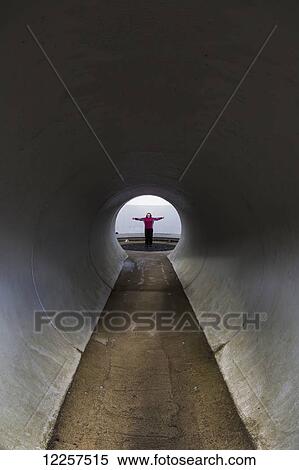 A person with outstretched arms standing at the end of a tunnel; Kielder, Northumberland, England View Large Photo Image Stock Photography - A person with outstretched arms standing at the end of a tunnel; Kielder, Northumberland, England. Fotosearch