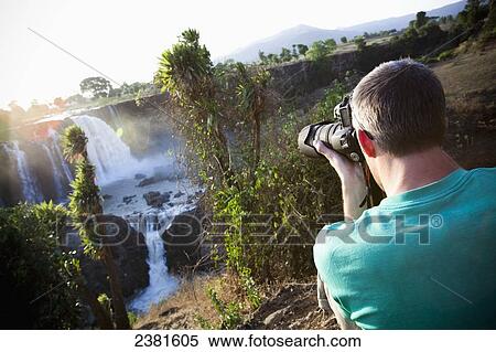 A photographer at Tis Issat (the Waters that Thunder), or the Blue Nile falls, near Bahir Dar; Amhara, Ethiopia View Large Photo Image Stock Photography - A photographer at Tis Issat (the Waters that Thunder), or the Blue Nile falls, near Bahir Dar; Amhara, Ethiopia. Fotosearch