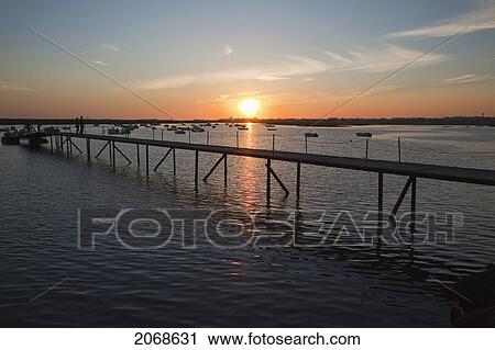 A Pier And Boats Moored In The Harbour At Sunset Near Faro; Algarve Portugal View Large Photo Image Stock Image - A Pier And Boats Moored In The Harbour At Sunset Near Faro; Algarve Portugal. Fotosearch