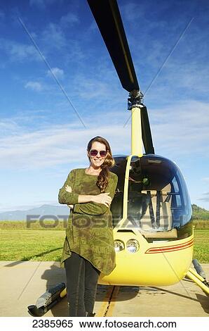 A pilot stands waiting with a helicopter on a landing pad; Kilauea, Hawaii, United States of America View Large Photo Image Stock Photography - A pilot stands waiting with a helicopter on a landing pad; Kilauea, Hawaii, United States of America. Fotosearch