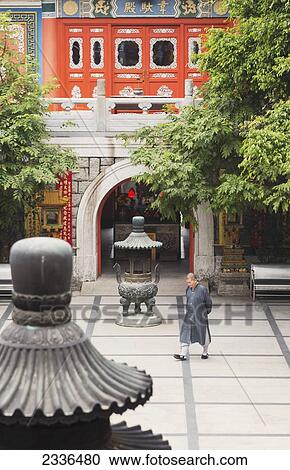 Stock Image - A Priest Walking Across The Monastery Courtyard, Po Lin Monastery, Lantou Island; Hong Kong, China. Fotosearch