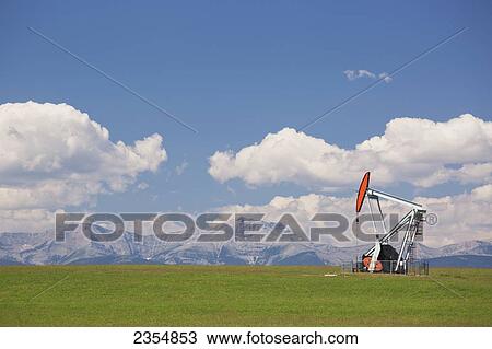 A Pumpjack In A Field With The Rocky Mountains In The Background; Alberta, Canada View Large Photo Image Stock Image - A Pumpjack In A Field With The Rocky Mountains In The Background; Alberta, Canada. Fotosearch
