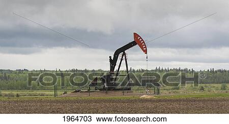 Stock Image - A Pumpjack On An Oil Well; Alberta Canada. Fotosearch