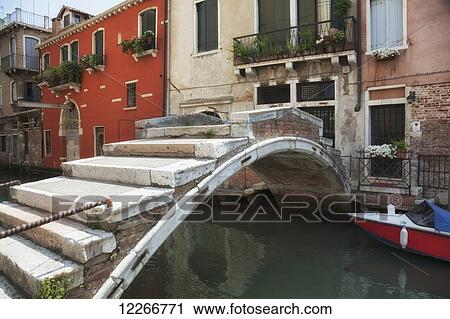 Stock Image - A quaint bridge crosses a small canal; Venice, Italy. Fotosearch