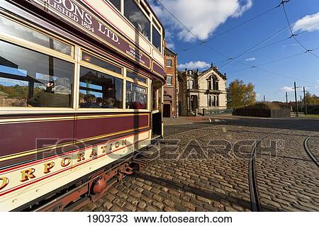Stock Image - A Rail Car Traveling On The Tracks In The Town; Beamish, Durham, England. Fotosearch