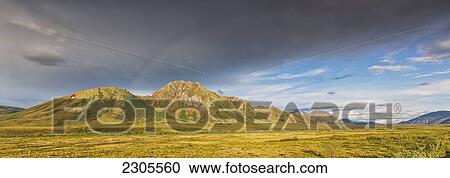Stock Image - A Rainbow Above Mountains Along The Dempster Highway; Yukon Canada. Fotosearch