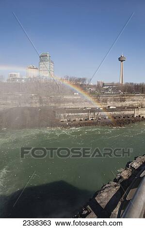 Stock Image - A Rainbow Over Niagara Falls And Gorge With Mist And Blue Sky; Niagara Falls, New York, United States Of America. Fotosearch