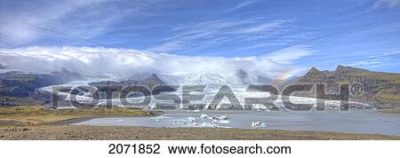 Stock Image - A Rainbow Over The Glacier Down The Mountain Off Of The Vatnajorkull Ice Cap, Skaftafell National Park, Iceland. Fotosearch