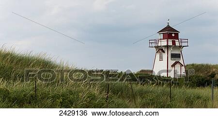 Stock Photograph - A red and white lighthouse on the Atlantic coast; Prince Edward Island, Canada. Fotosearch