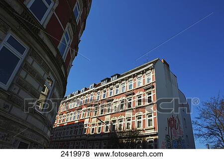 Stock Photo - A residential building with graffiti painted on the side and a blue sky; Hamburg, Germany. Fotosearch