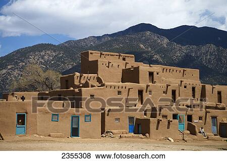Stock Photo - A Residential Building With Mountains In The Background; Taos Pueblo, New Mexico, United States Of America. Fotosearch
