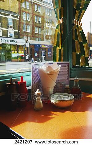 A restaurant table set with condiments and a menu, Shoreditch; London, England View Large Photo Image Stock Photo - A restaurant table set with condiments and a menu, Shoreditch; London, England. Fotosearch