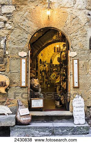Stock Photo - A retail store with an open arched doorway; Montepulciano, Tuscany, Italy. Fotosearch