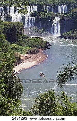 Stock Image - A RIB boat takes tourists to see the waterfalls from the Brazilian side of the river at Iguacu National Park; Brazil. Fotosearch