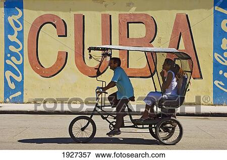 A Ricksaw Passes A Viva Cuba Sign, Havana, Cuba View Large Photo Image Stock Photo - A Ricksaw Passes A Viva Cuba Sign, Havana, Cuba. Fotosearch