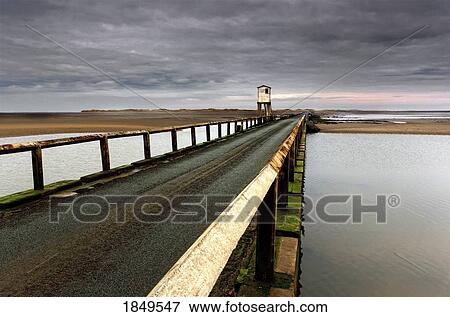 A Road Going Over Water Towards A Beach; Northumberland, England View Large Photo Image Stock Photo - A Road Going Over Water Towards A Beach; Northumberland, England. Fotosearch