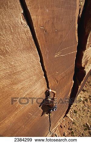 Stock Photo - A rock climber climbing Blue Sun 5. 10; Indian Creek, Utah, United States of America. Fotosearch