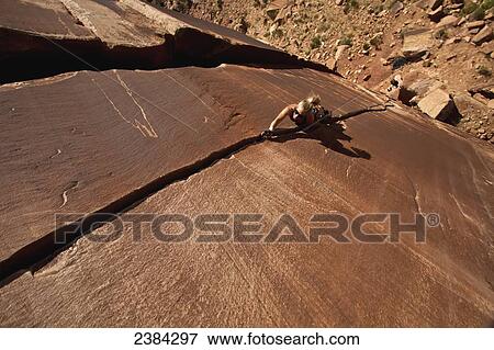 Stock Photo - A rock climber on Blue Sun 5. 0; Indian Creek, Utah, United States of America. Fotosearch