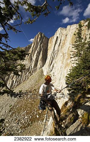 A rock climber rappeling in the Lone Peak Cirque, Wasatch Range; Utah, United States of America View Large Photo Image Stock Image - A rock climber rappeling in the Lone Peak Cirque, Wasatch Range; Utah, United States of America. Fotosearch