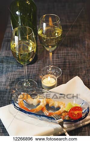 Stock Photograph - A romantic candlelight dinner for two is set out with wine glasses and a heart shaped seafood appetizer; Fort McMurray, Alberta, Canada. Fotosearch
