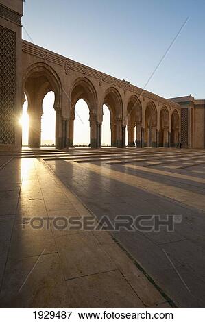 Stock Photo - A row of archways against a blue sky and sunlight shining through; Casablanca, Morocco. Fotosearch