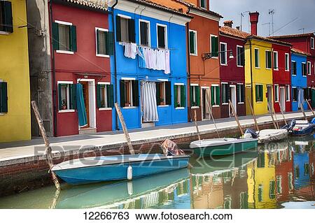 A row of brightly coloured houses sit along a canal with boats; Burano, Venice, Italy View Large Photo Image Stock Image - A row of brightly coloured houses sit along a canal with boats; Burano, Venice, Italy. Fotosearch