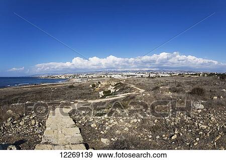 Stock Photo - A rugged stone path across an arid landscape at the water's edge; Paphos, Cyprus. Fotosearch