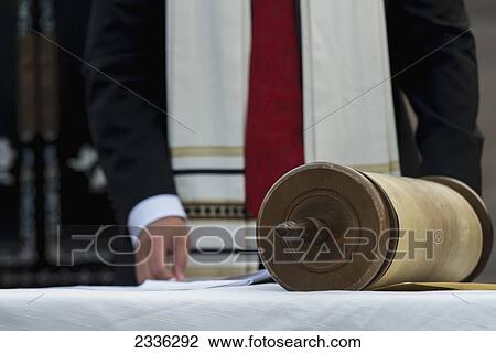 Stock Image - A Scroll And A Man Standing Behind A Table Wearing A Robe; Beijing, China. Fotosearch