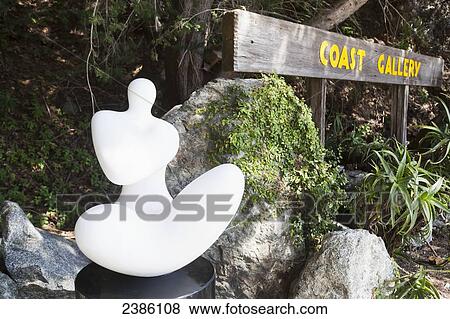 A sculpture beside a wooden sign for Coast Gallery; California, United States of America View Large Photo Image Stock Photo - A sculpture beside a wooden sign for Coast Gallery; California, United States of America. Fotosearch