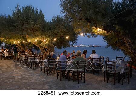 A seafront taverna at dusk in Platis Ghialos; Sifnos, Cyclades, Greek Islands, Greece View Large Photo Image Stock Image - A seafront taverna at dusk in Platis Ghialos; Sifnos, Cyclades, Greek Islands, Greece. Fotosearch